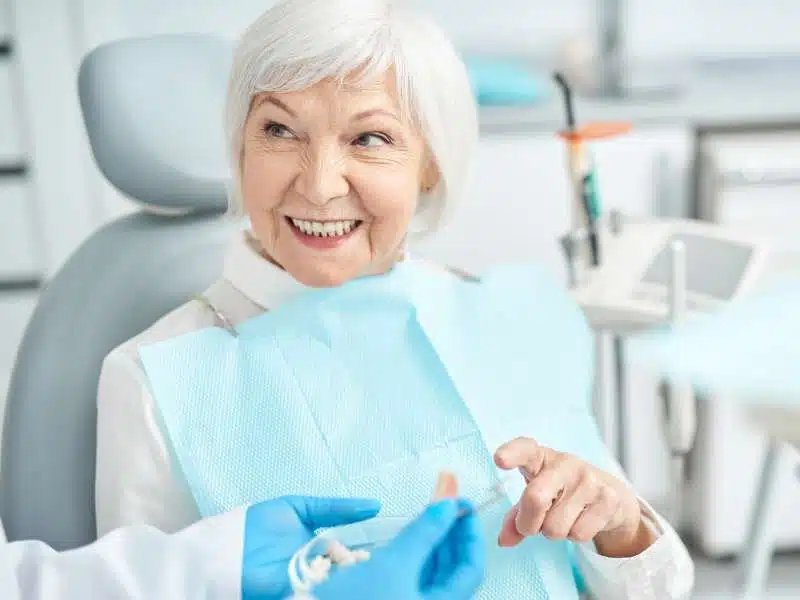 Happy patient smiling after getting dentures in Troy, IL